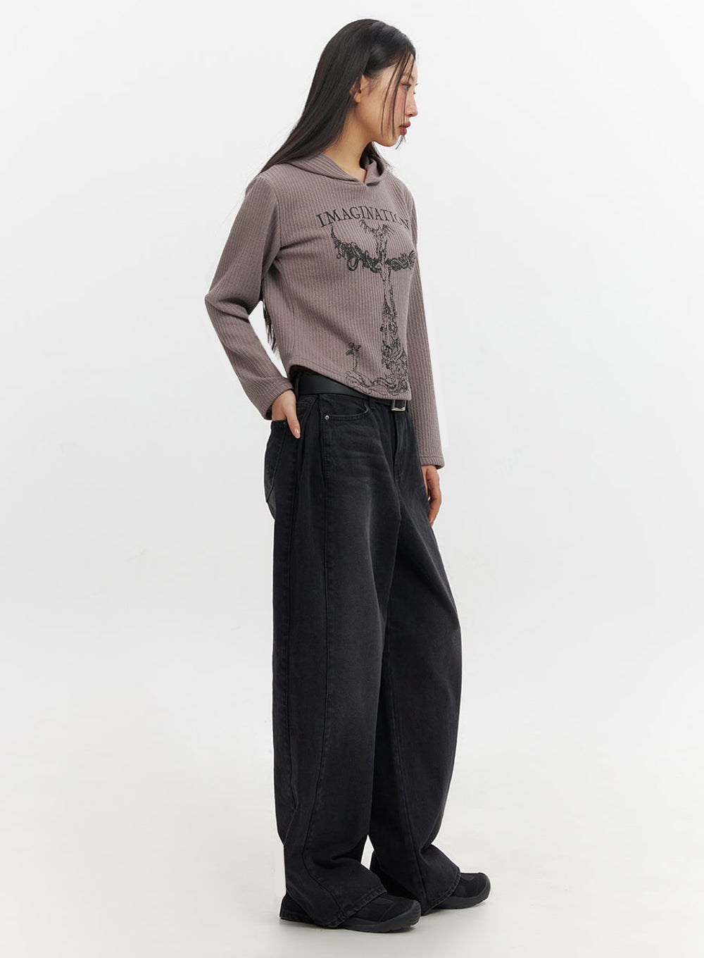 Ashly Wide-Leg Jeans IF511 in washed black, side full-length on model looking right, baggy wide-leg fit with black belt at waist, paired with cropped graphic hoodie.