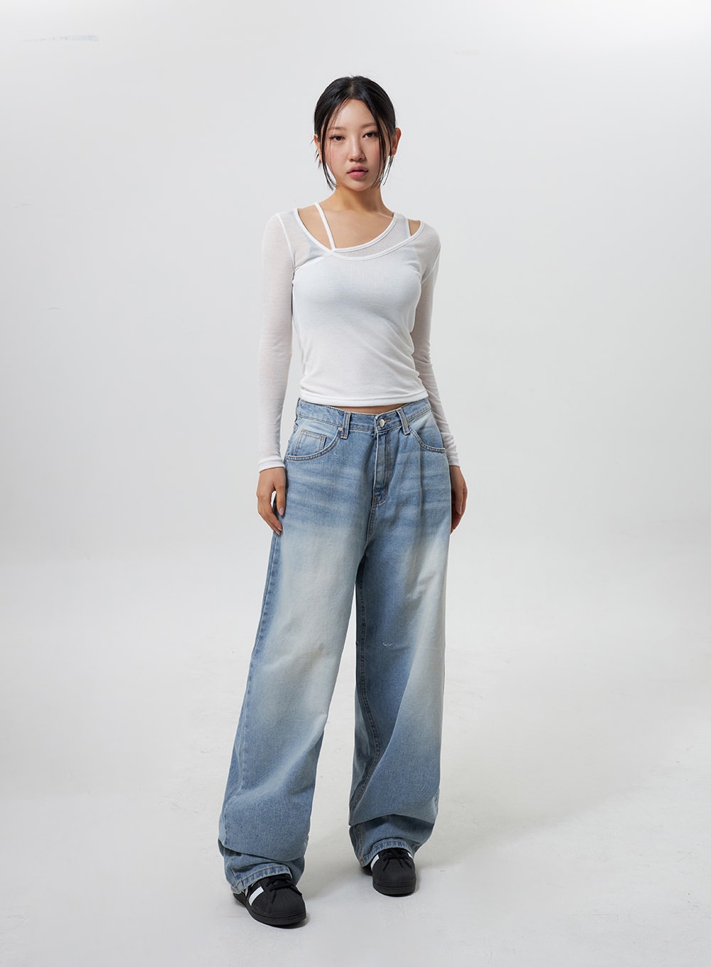Low Rise Baggy Jeans CY324 in light blue, full-length front view on model standing straight, relaxed low-waist wide-leg denim with gradient fade, styled with white mesh layered long-sleeve top.