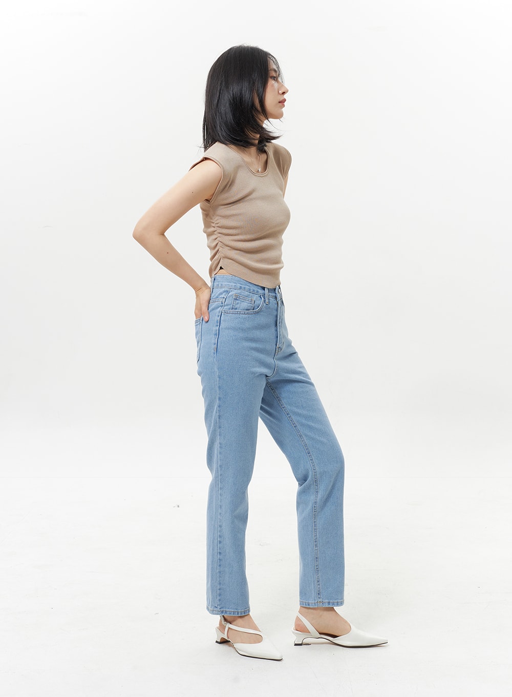 High Waist Jeans OY330 in light blue, side model shot with hand on hip, straight-fit denim highlighting elongated leg line and high waist, worn with beige sleeveless top.
