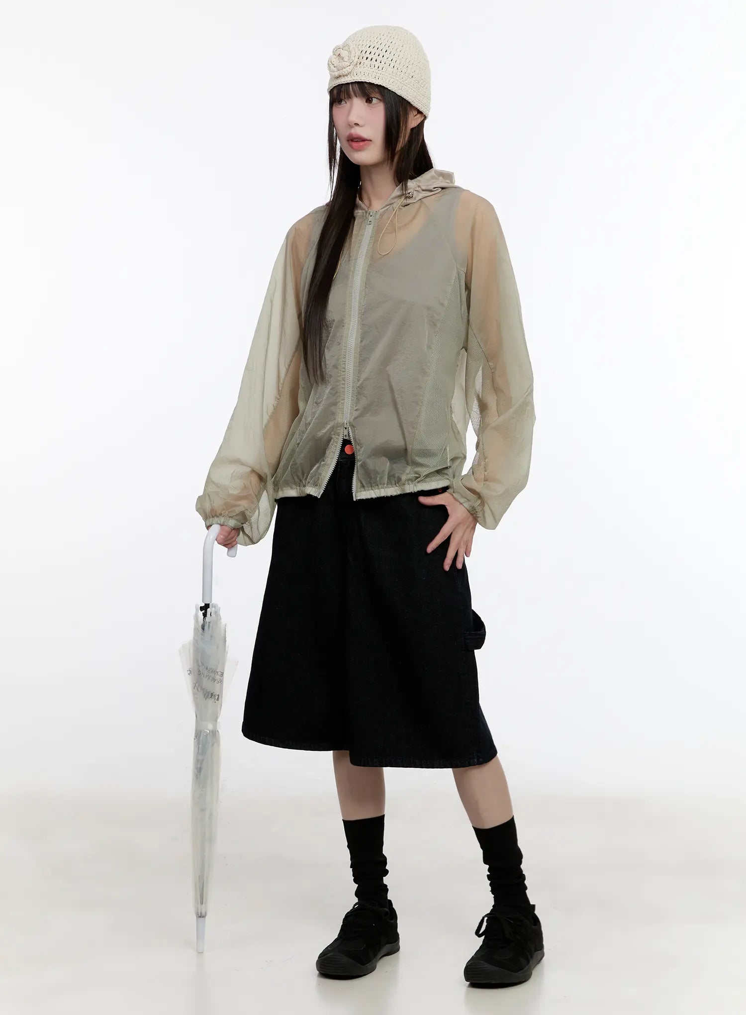 Red Text Graphic Embroidered Jorts CL504 in black, front full-body editorial shot, wide-leg denim styled with sheer hooded jacket, knit hat, and clear umbrella for street look.