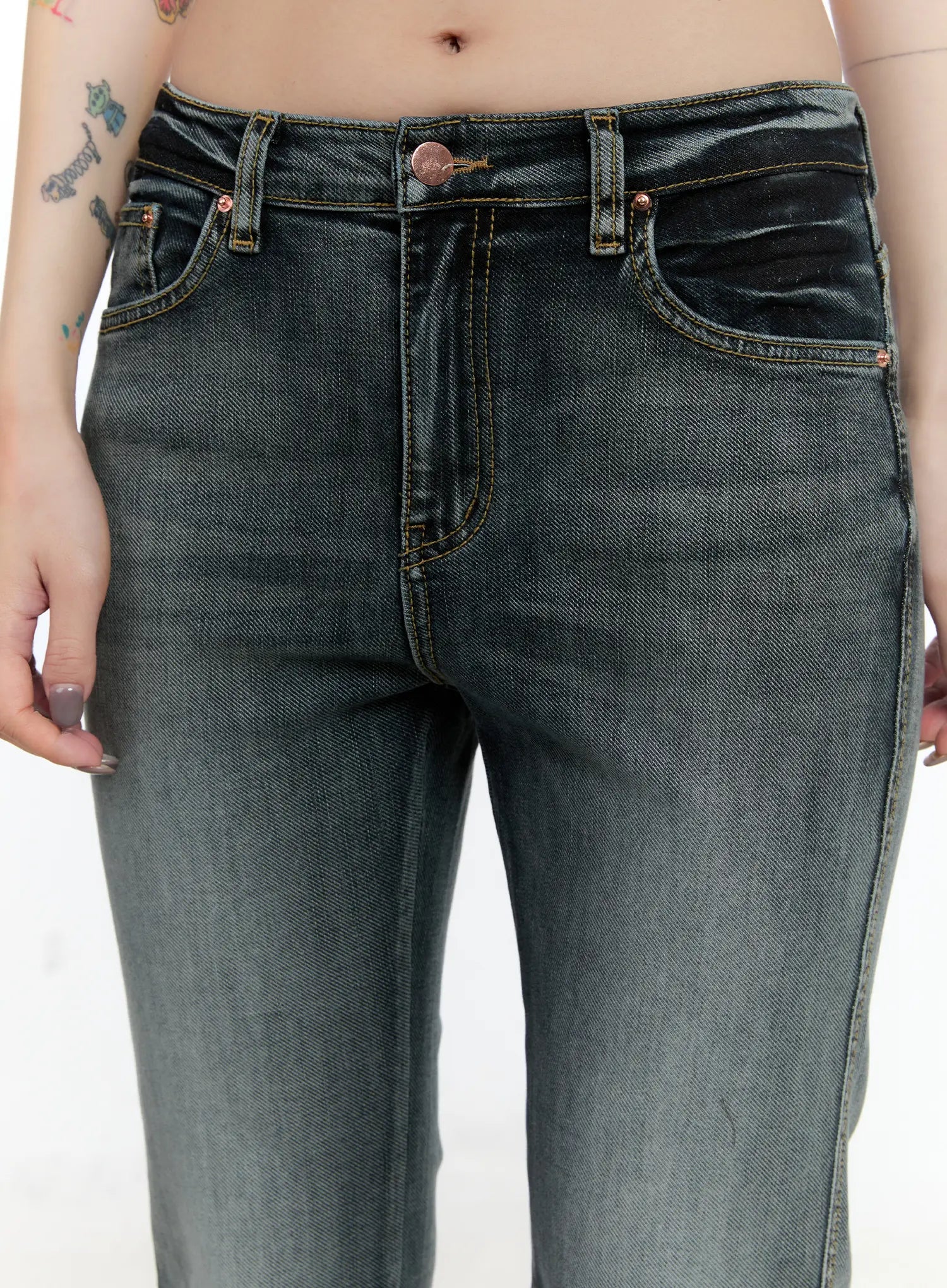 Judith Washed Bootcut Jeans CN517 in blue, close-up front waist detail on model, rose-gold button, contrast gold topstitching on front pockets, washed grey denim with subtle fading.