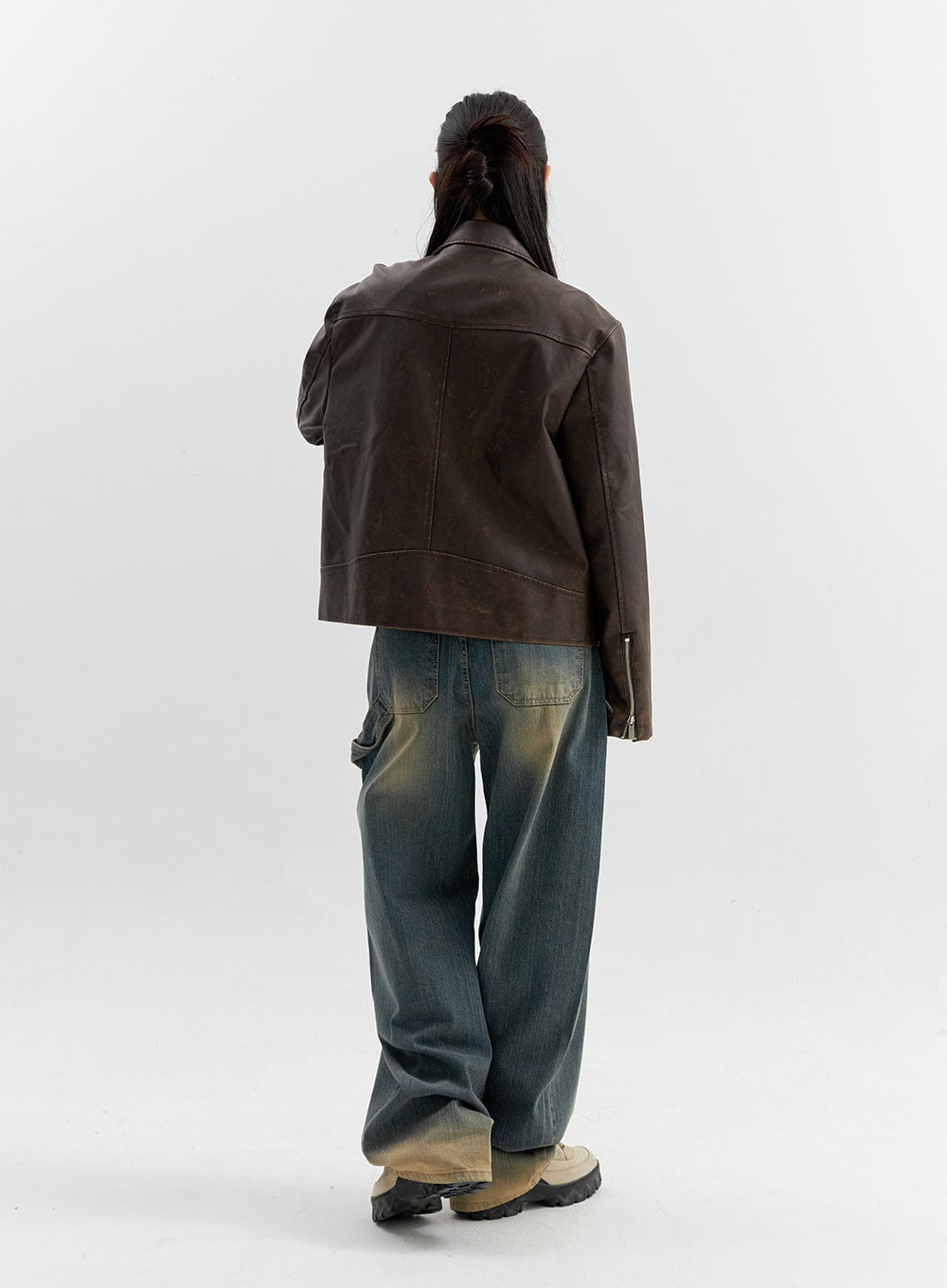 Vintage Wash Wide Leg Jeans CO306 in blue, full back view on model, wide-leg carpenter-style denim, patch pockets and yellow-faded vintage wash, paired with brown leather jacket.