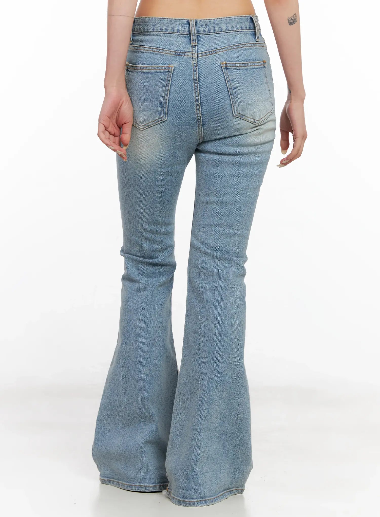 Byeol Washed Flare Denim Jeans CL525 in light blue, back view on model, rear pockets with stitching, slim fit through hips flaring to wide bell hem, washed cotton denim.