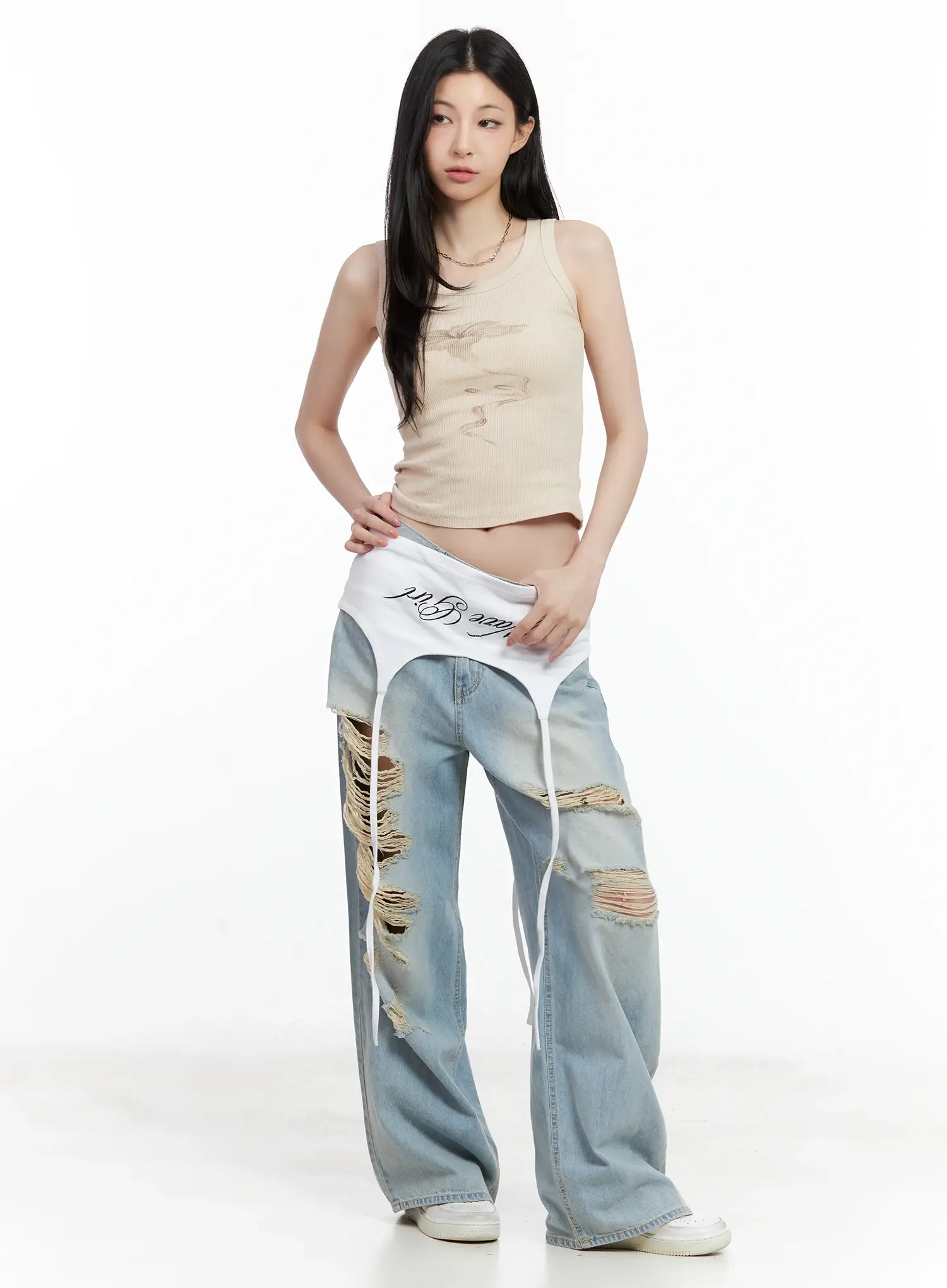 Gyuri Dirty-Wash Distressed Wide Jeans CU530 in blue, full-body front on model lifting layered skirt waistband over jeans, heavy frayed rips, beige crop tank, white sneakers.