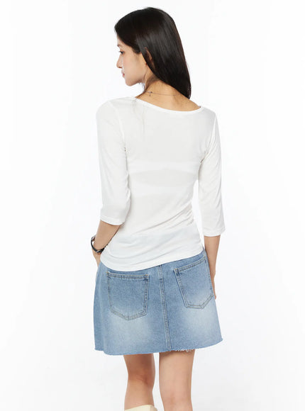Sheer Three-Quarter Sleeve Top CU522 in white, back view on model, smooth sheer fabric with clean back neckline and three-quarter sleeves, paired with light blue denim mini skirt.