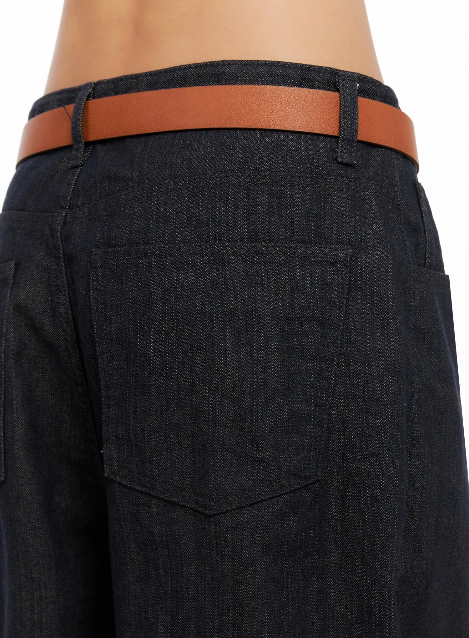 Heidi Wide-Leg Jeans IG527 in dark blue, back waist close-up on model, large patch back pockets and denim texture detail with slim tan belt threaded through loops.