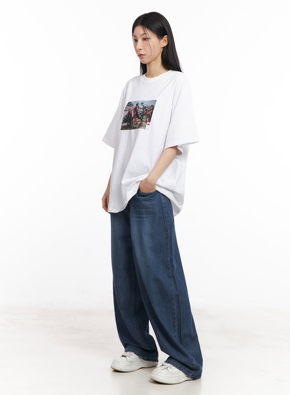 Martha Baggy Jeans IY529 in dark blue, three-quarter side shot on model looking aside, wide-leg washed denim with slouchy silhouette, paired with white oversized graphic tee.