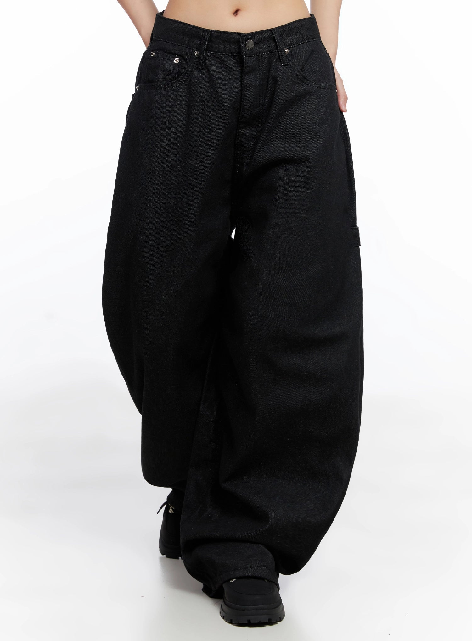 Lea Cross-Patch Baggy Jeans IS525 in black, front walking shot on model, oversized baggy cotton denim with voluminous wide leg and silver rivet accents, full-length view showing hem pooling at boots.