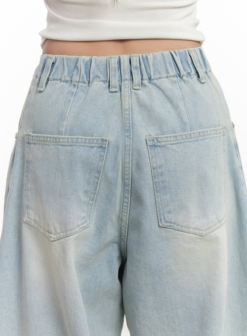 Alia Washed Wide-Leg Jeans CA518 in light blue, close-up detail of back waistband and pockets, elastic waistband with gathered denim, dual patch pockets, sun-bleached washed finish.