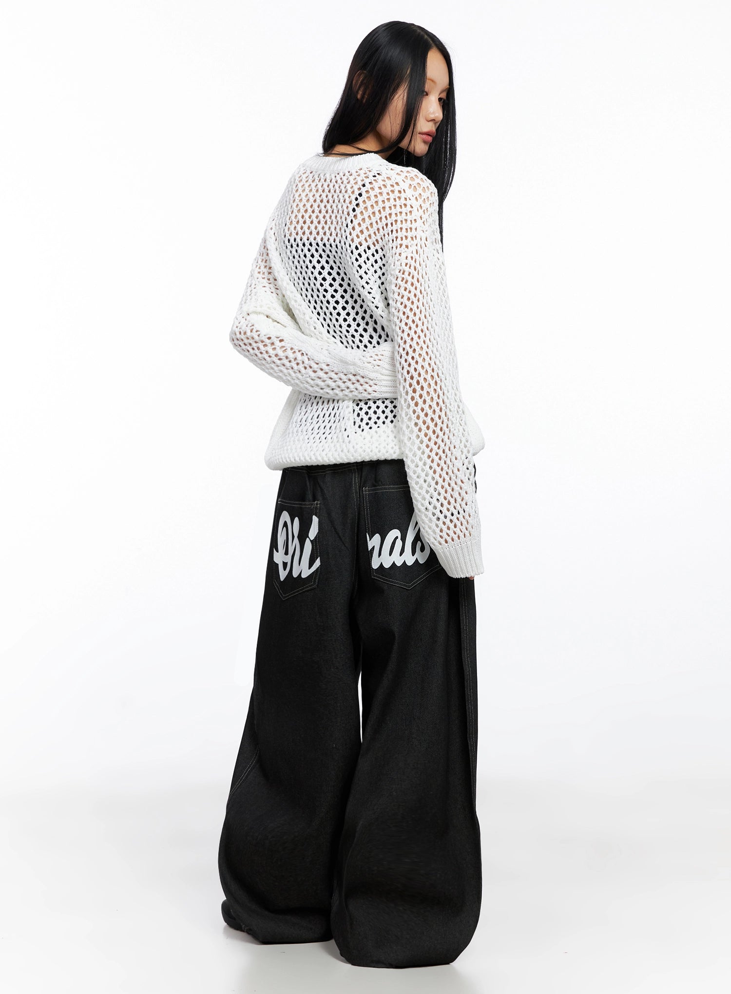Ayra Graphic Baggy Jeans IO516 in Black, back three-quarter on model, cursive Originals lettering across banded back pockets, contrast stitching, paired with white open-knit mesh top.