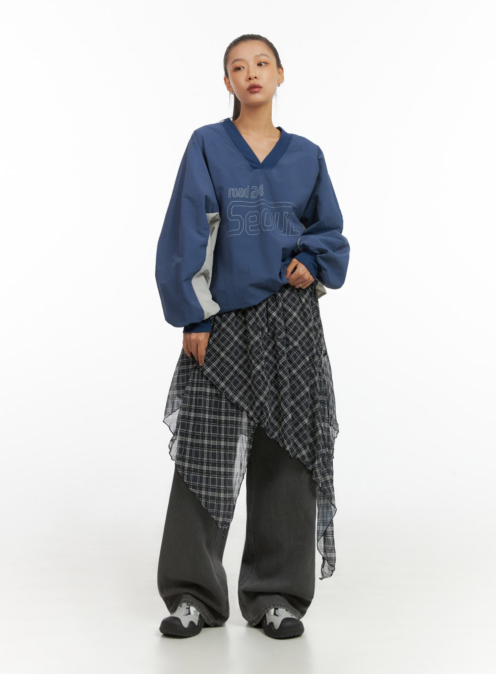 Emery Cotton Strap Baggy Jeans IO409 in dark gray, full-body front editorial shot on model, baggy denim layered under asymmetric plaid mesh skirt, styled with blue v-neck sweatshirt.