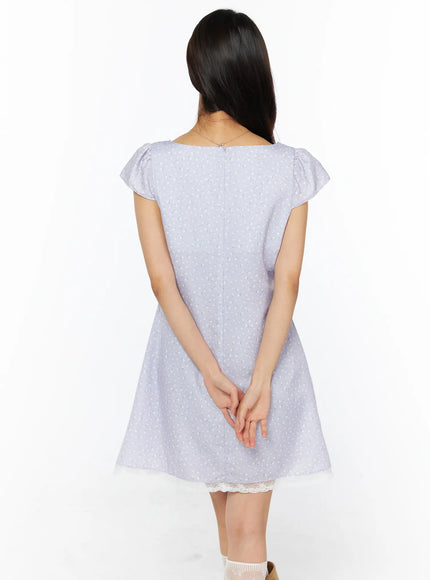 Romantic Floral Lace Trim Mini Dress CU522 in light purple, back full view on model, flutter cap sleeves and A-line silhouette from behind, center back zip, cream lace hem, lace socks and tan boots.