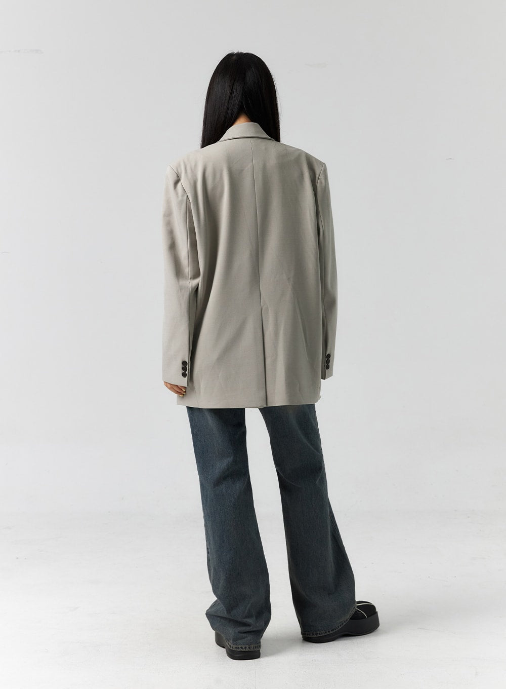 Vintage Wash Bootcut Jeans CS305 in blue, back full-body on model, showing bootcut hem width and vintage-washed denim, styled with oversized beige blazer.