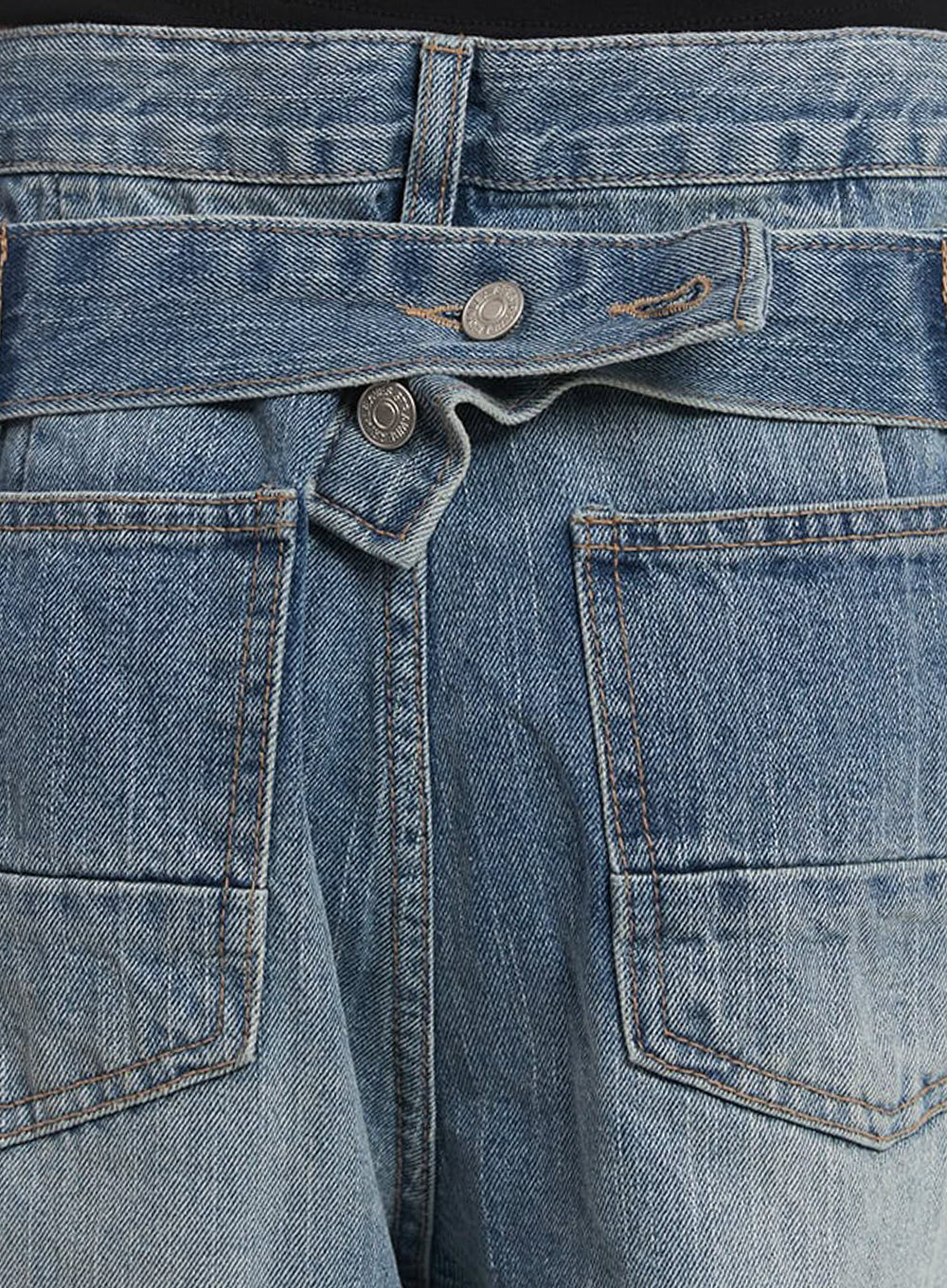 Yvette Washed Baggy Jeans IA517 in light blue, macro close-up of back waistband detail, crossover denim tab with metal buttons and dual patch pockets, washed cotton twill texture clearly visible.