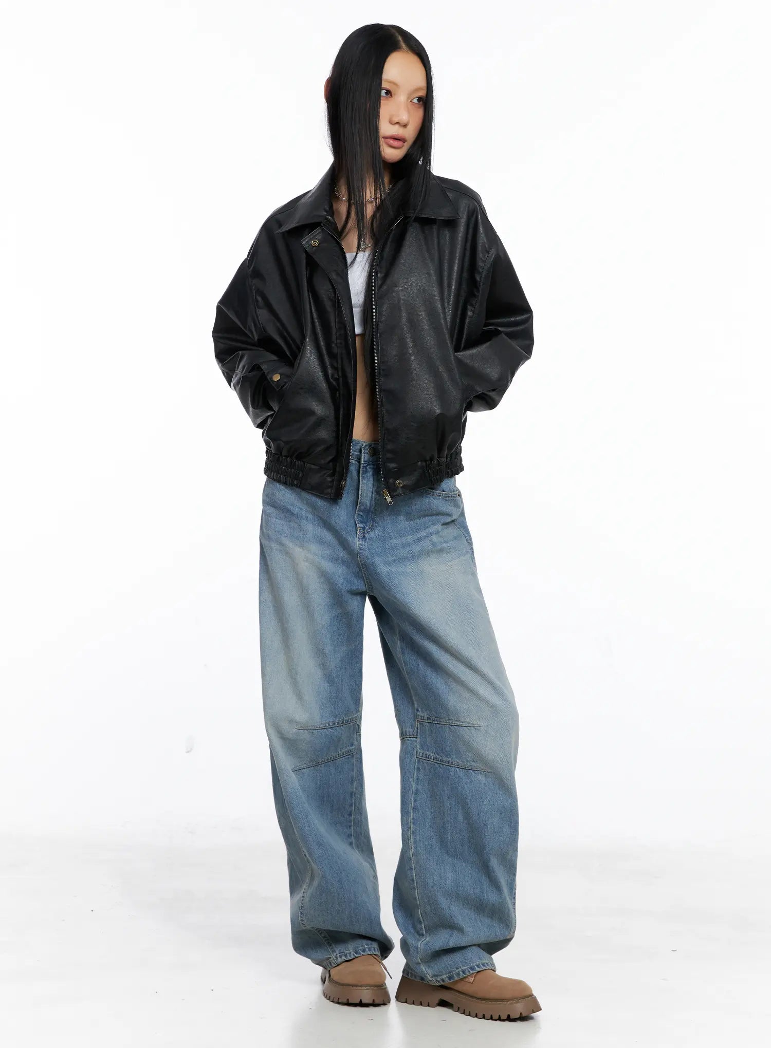 Dakota Relaxed Fit Vintage Wash Jeans CS511 in blue, full-length front studio shot on model, wide-leg low-rise jeans with knee panel detail, styled with black oversized leather bomber jacket and tan boots.