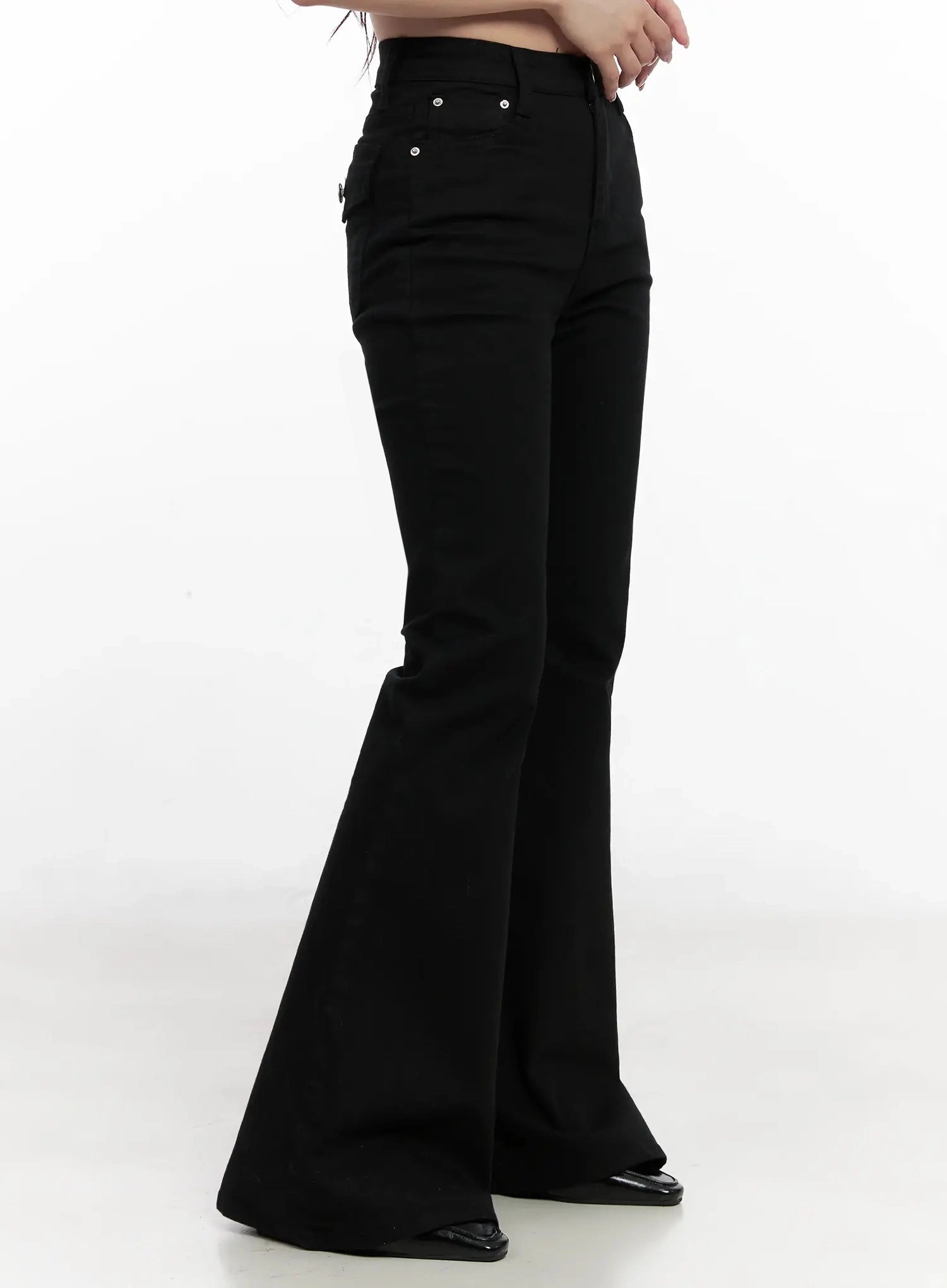 Dream Chic Black Flare Jeans IN514 in black, side close-up on model from waist to floor, side-seam silhouette highlighting fitted thigh and dramatic wide flare hem sweep.