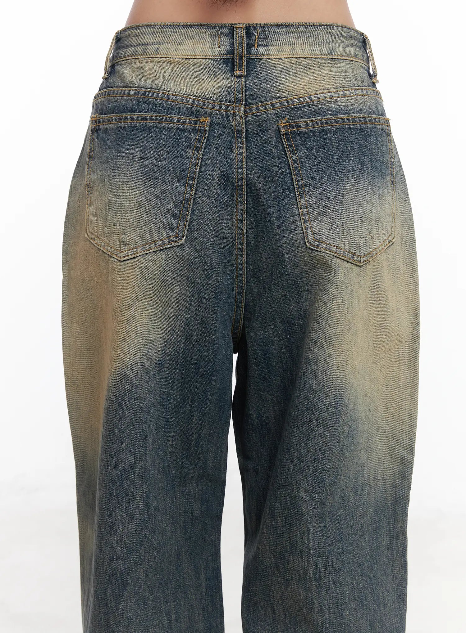Wide Washed Jeans CS06 in vintage blue, back waist close-up on model, wide-leg washed denim highlighting rear patch pockets, contrast stitching, and sandy yellow fade across the seat and upper leg.