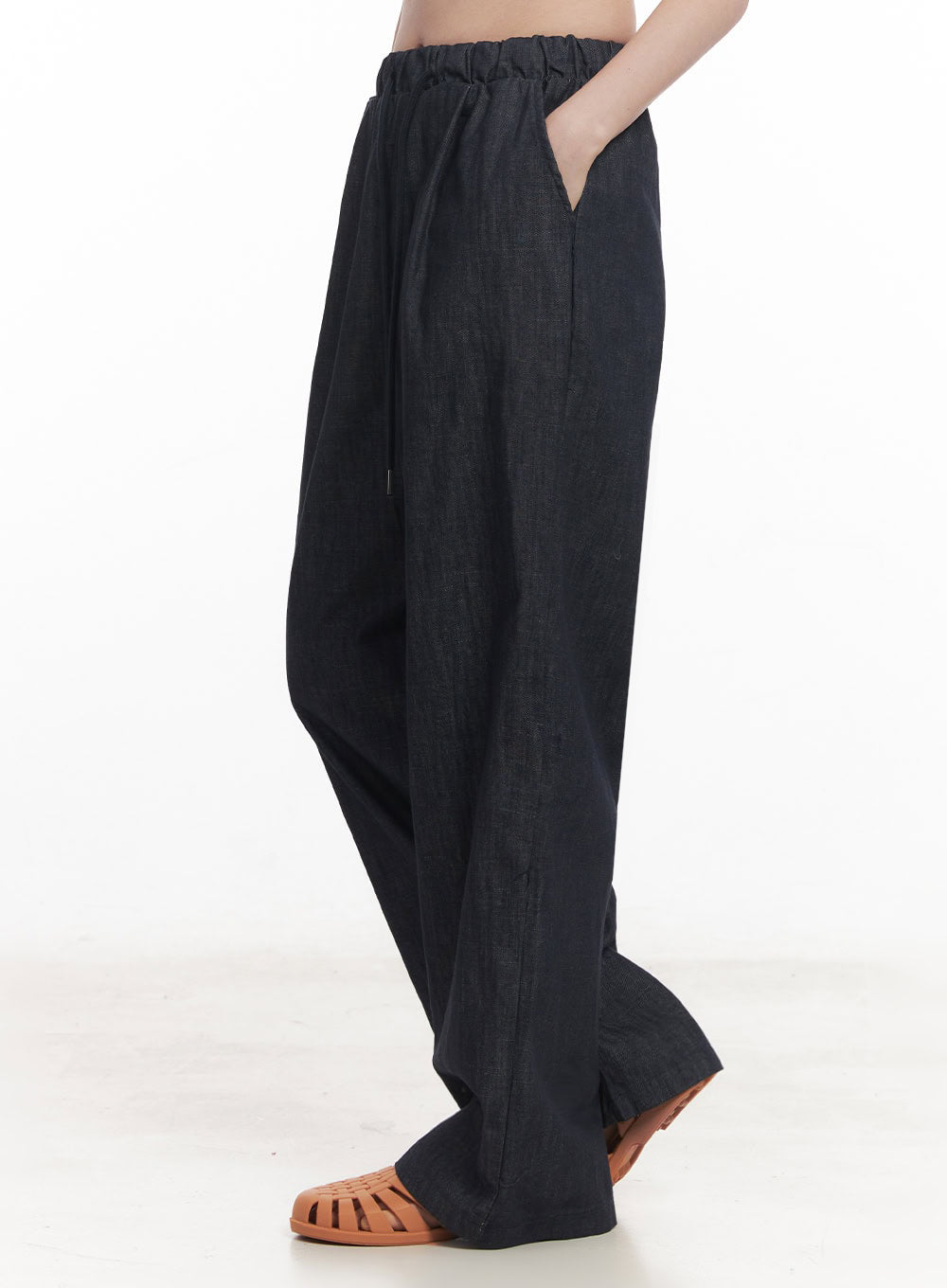 Cotton Denim Wide-Leg Pants IY509 in dark navy, side mid-body close-up on model, showing side pocket, ruched elastic waistband with dangling drawstring, and wide-leg cotton denim silhouette.