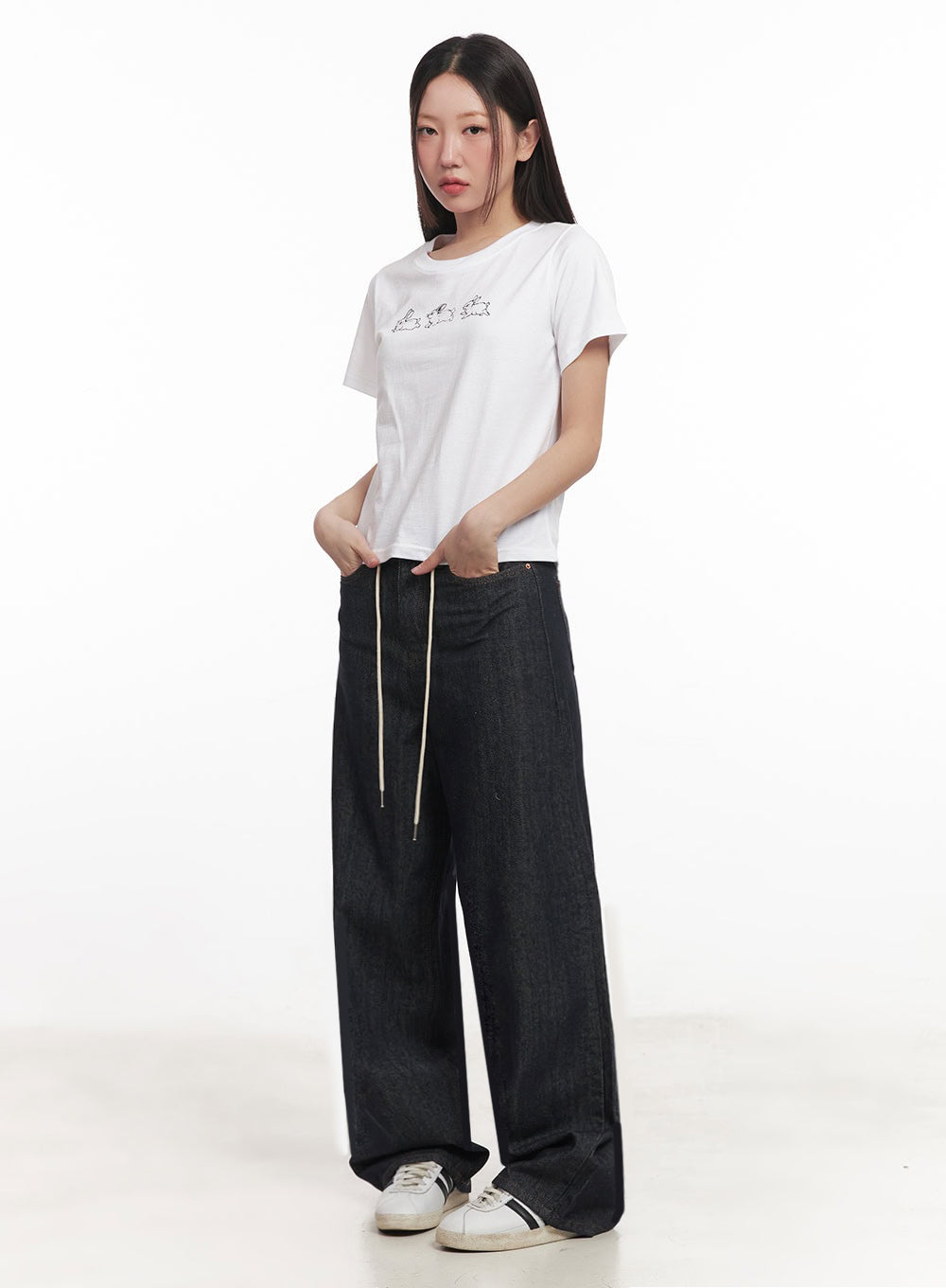 Kirsten String Wide-Leg Summer Denim Jeans IM528 in dark blue, side-angled view on model, wide-leg silhouette with cream string at waist, tucked hands in pockets, paired with white tee.