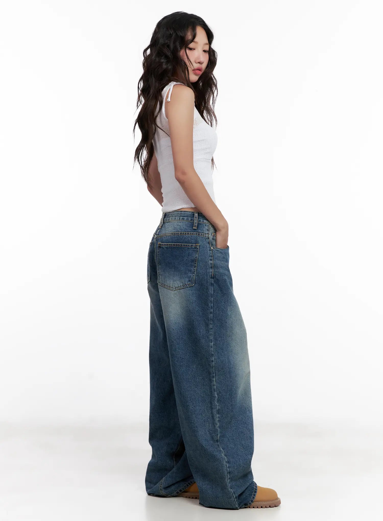 Miji Wide-Leg Washed Denim Jeans CL521 in dark blue, side view full-body on model looking over shoulder, wide balloon leg silhouette with back pocket detail, styled with white ribbed crop tank.