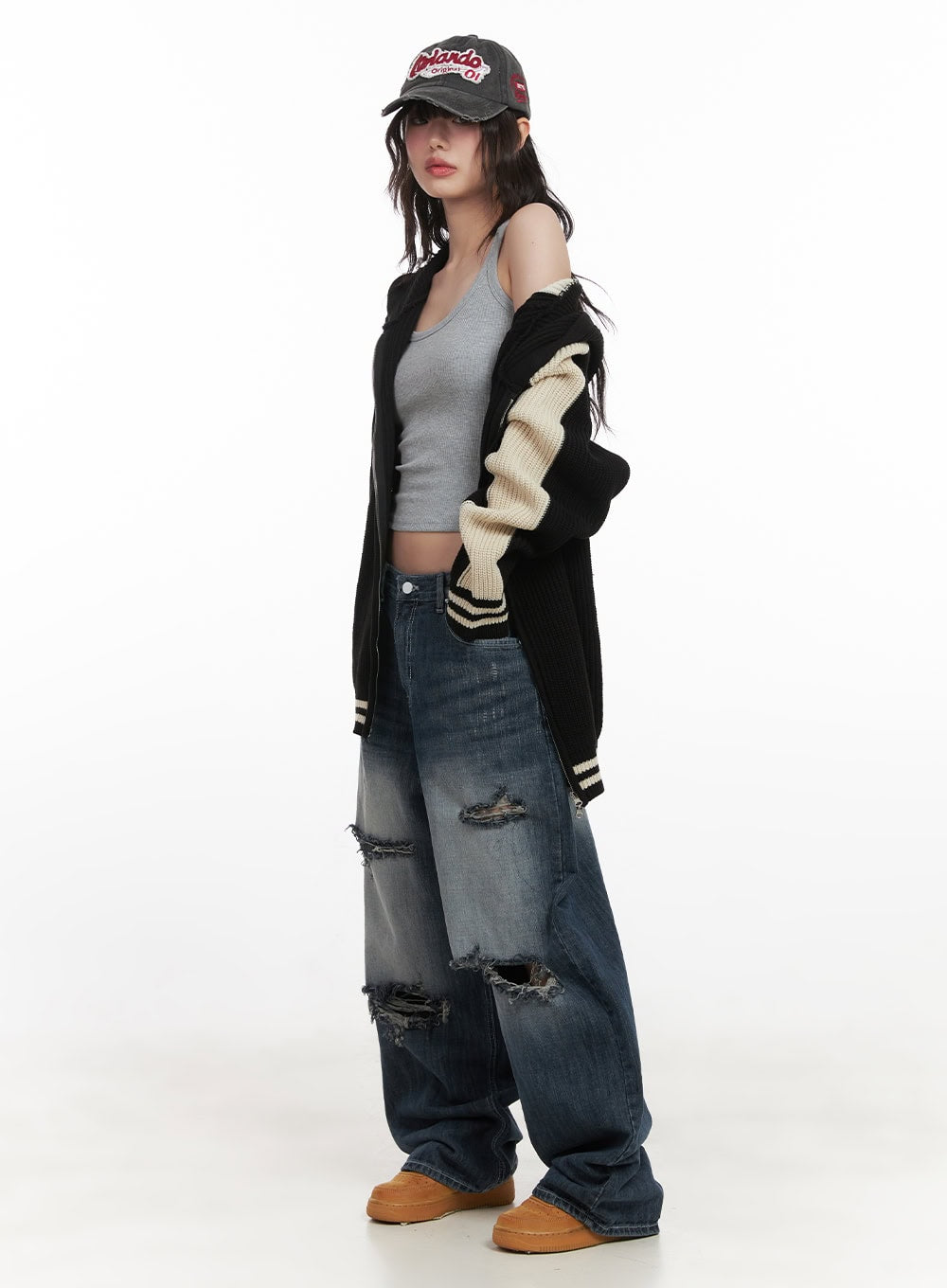 Alison Destroyed Baggy Jeans CJ523 in dark blue, full-body side editorial shot on model in black varsity cardigan and cap, wide destroyed denim with washed fade and frayed tears.