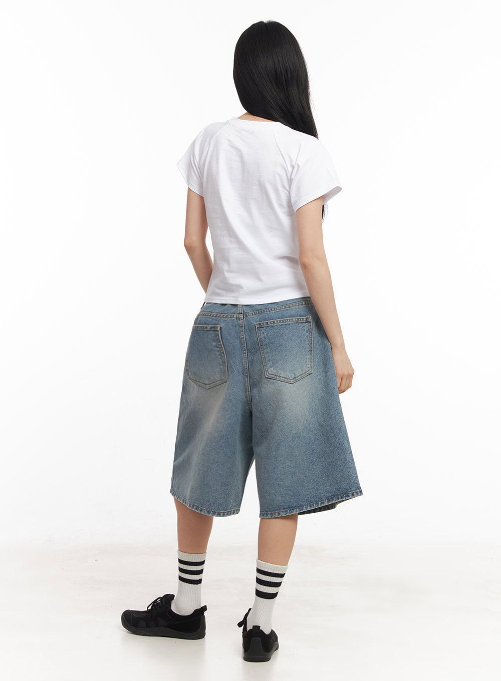Washed Baggy Jorts IY529 in light blue, full-body back shot on model, wide-fit midi washed denim with back pockets, styled with white crop tee and black sneakers.