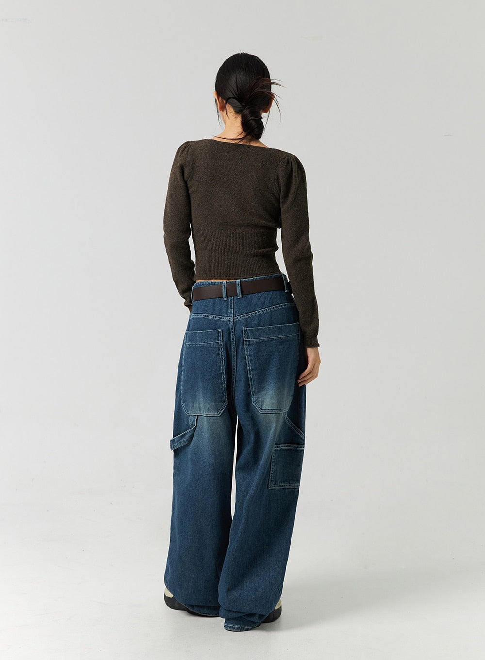Washed Cotton Wide Leg Jeans CO323 in blue, full-body back view on model, oversized patch pockets and utility cargo pockets on washed denim, wide leg silhouette with brown leather belt.