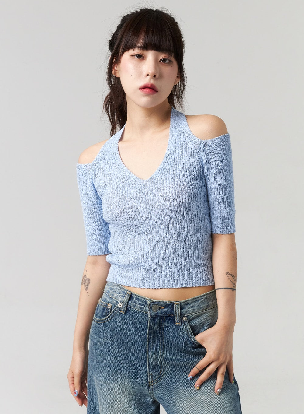 Mid-Wash Baggy Jeans CL312 in mid-wash blue, upper-body close-up on model showing waistband detail, low-rise fit with washed denim waistband, paired with blue ribbed halter crop knit.
