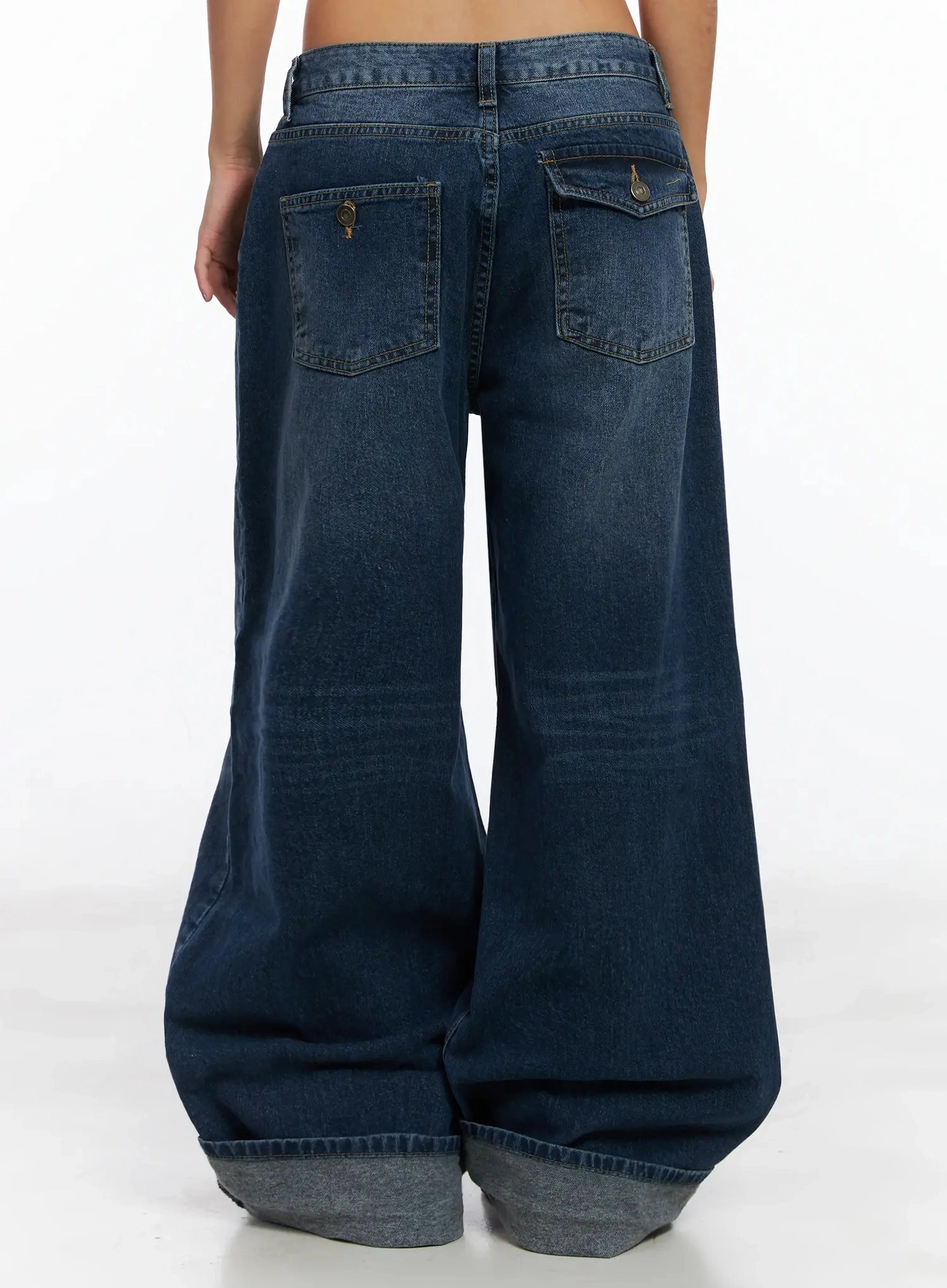 Anahi Baggy Jeans IN528 in blue, back waist-to-ankle shot on model, dual back patch pockets with brass button closures, wide leg and rolled cuff clearly shown.