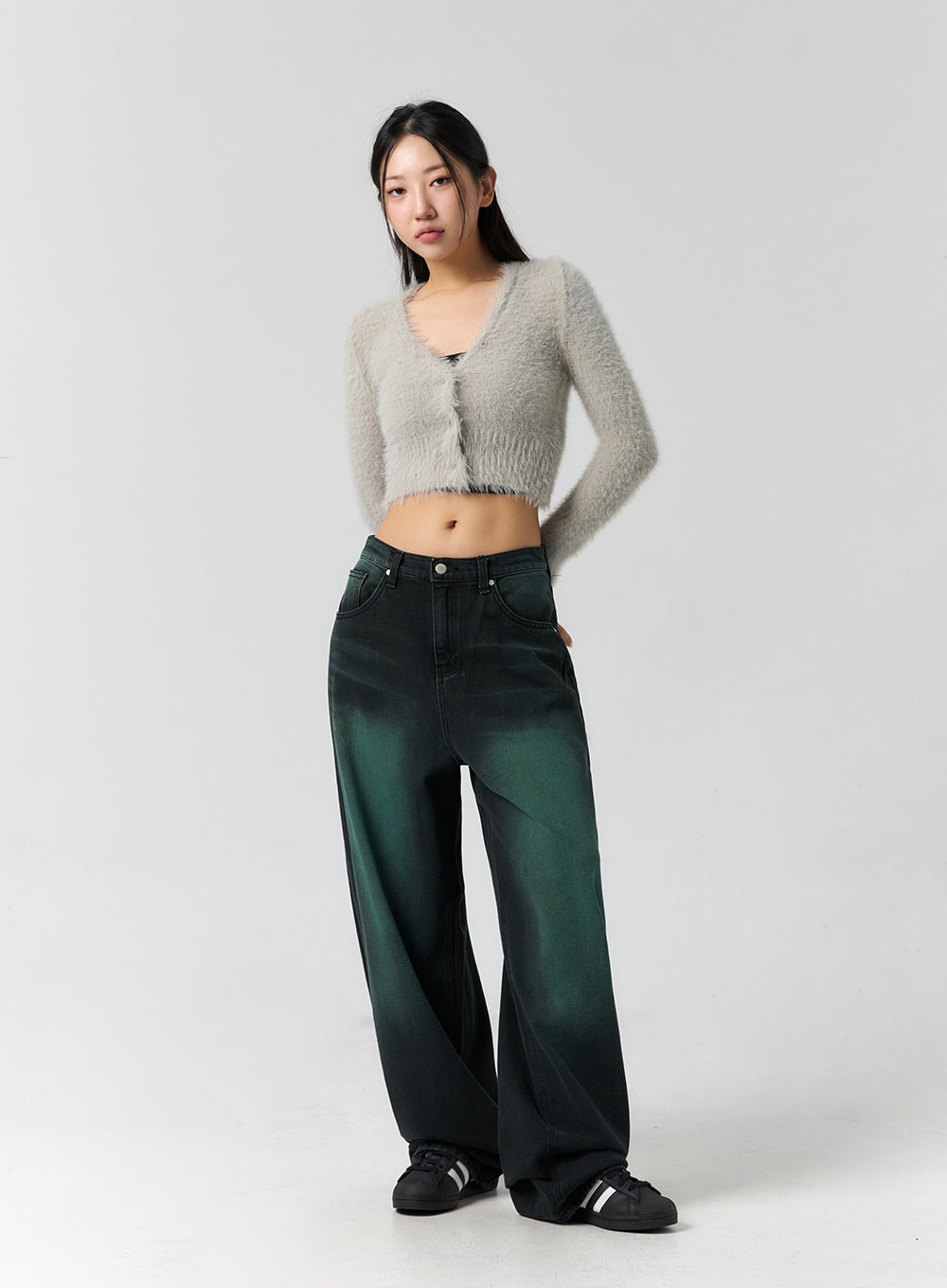 Comfy Wide Leg Color Jeans CS305 in dark green, full-length slight side-front view on model, wide-fit faded green denim with relaxed drape, styled with grey fluffy crop cardigan and sneakers.