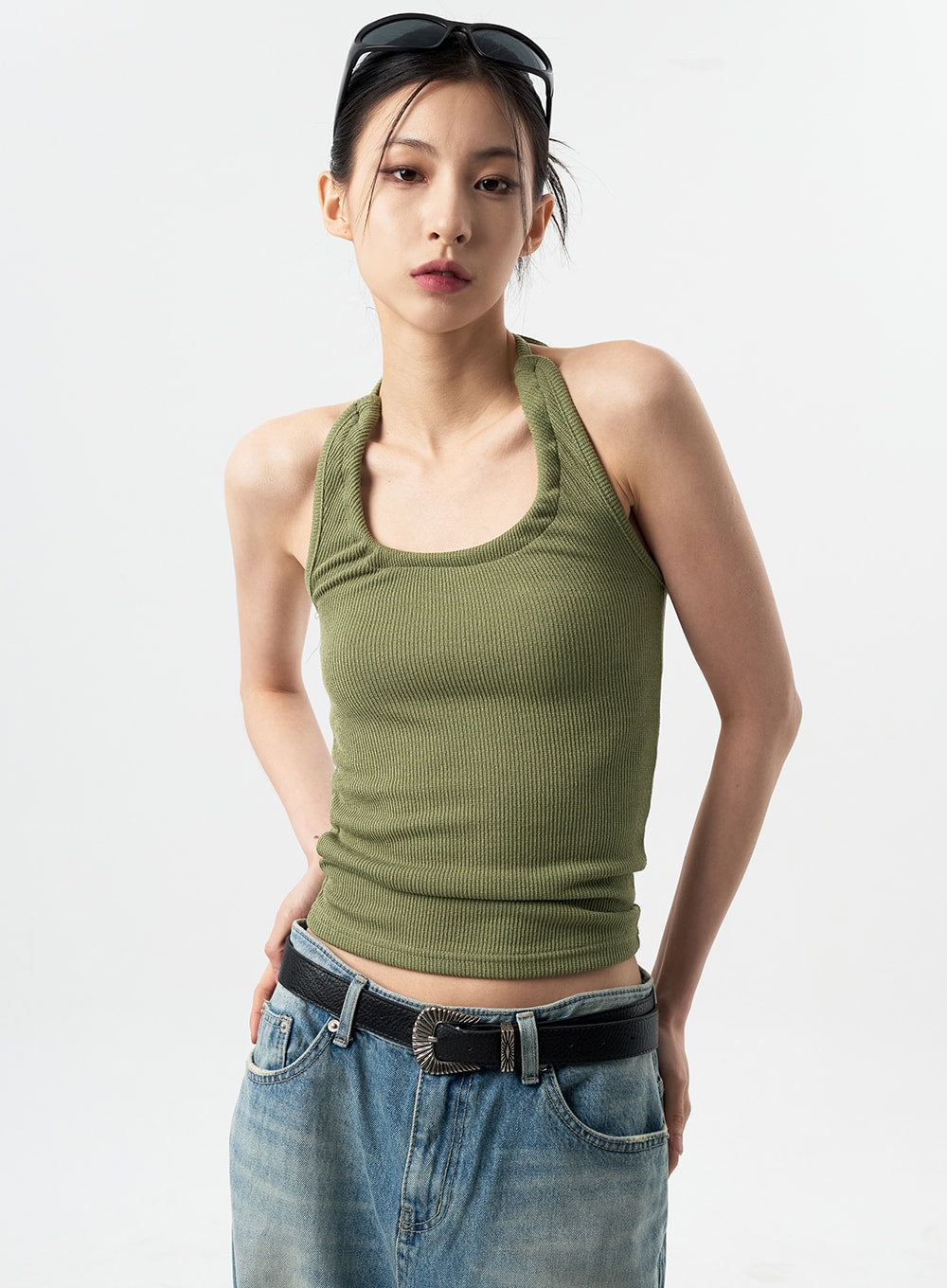 Oversized Jeans Unisex CY312 in washed blue, upper waist close-up on model, showing waistband, front pockets, and black western belt against ribbed green halter top.