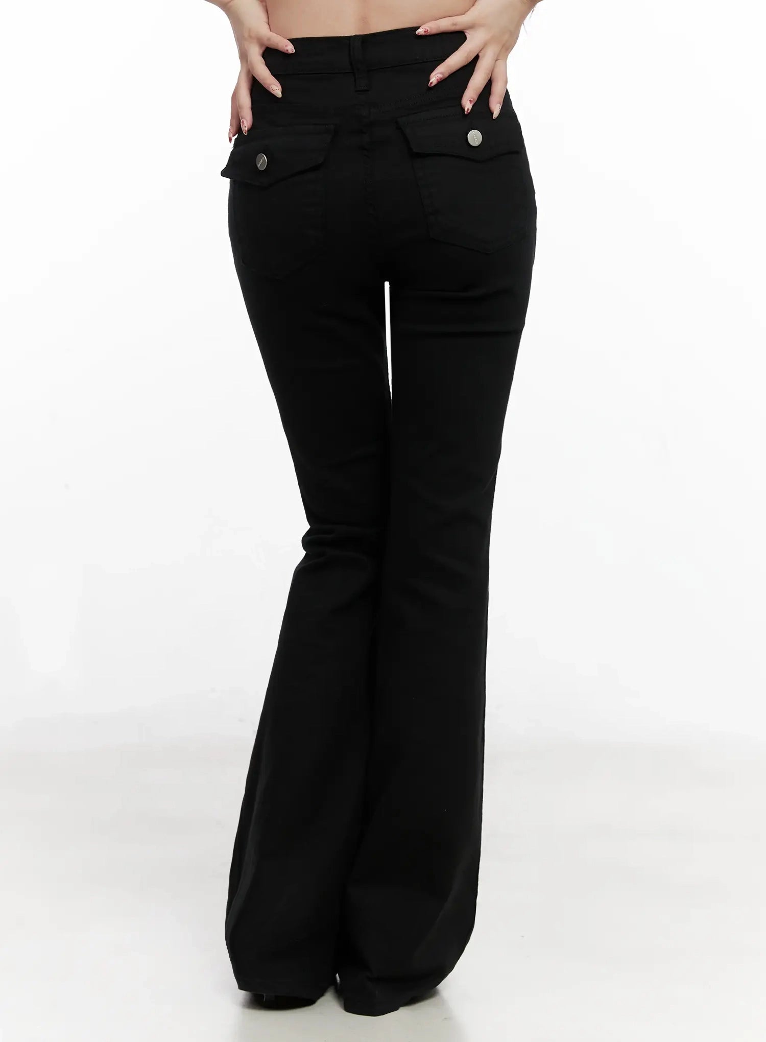 Dream Chic Black Flare Jeans IN514 in black, back waist-to-hem shot on model, snap-button flap back pockets detail, smooth solid fabric, flare leg from behind.