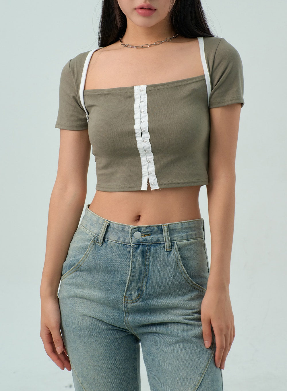 Straight Leg Jeans CY330 in light blue wash, upper-body and waistband close-up on model, high-rise waist with button closure and diagonal curved seam detail, paired with olive crop top.