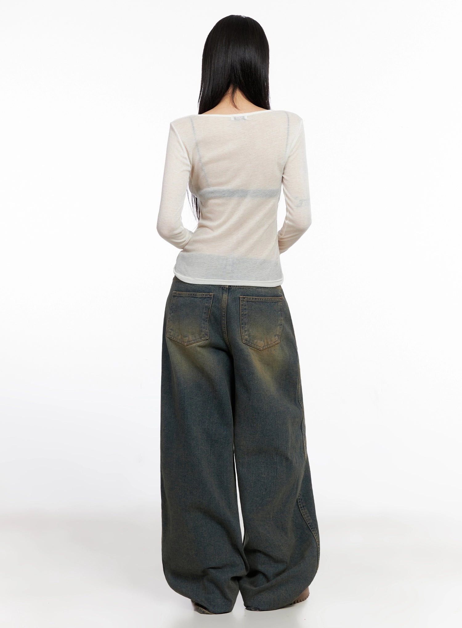 Minju Vintage Washed Baggy Jeans IS508 in dark blue, back full-length on model, styled with sheer white long sleeve top, showing back pockets and pooling wide hem on chunky boots.