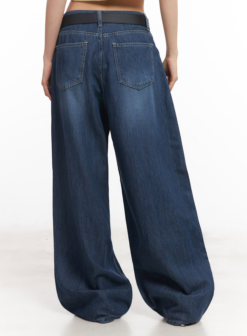 Martha Baggy Jeans IY529 in dark blue, back view on model, showing two back pockets with topstitching, washed denim, wide-leg hem pool, and black belt at waistband.
