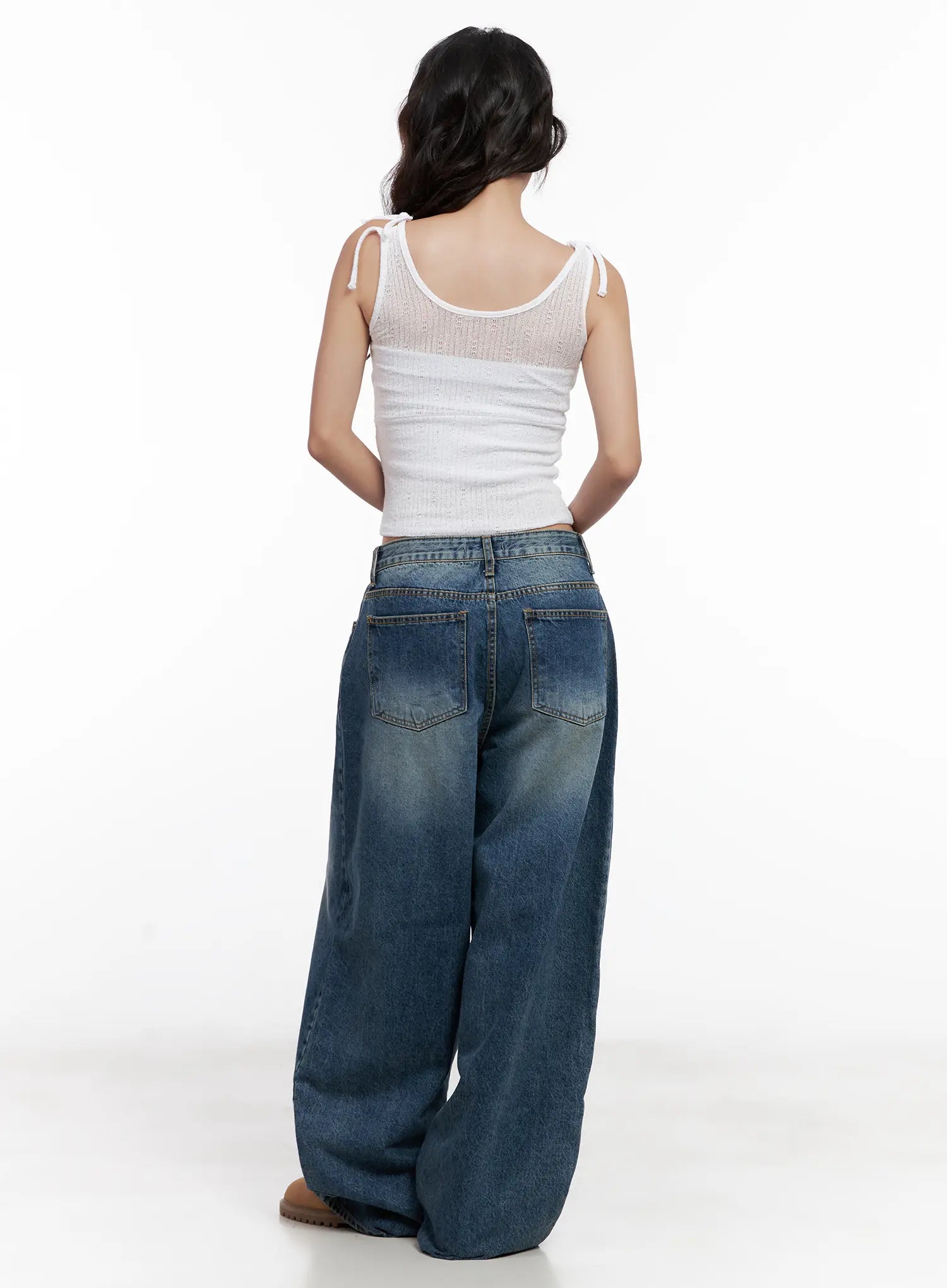 Miji Wide-Leg Washed Denim Jeans CL521 in dark blue, full back view on model, back pockets with topstitching and washed fade detail, wide-leg hem pooling, paired with white tie-shoulder crop top.