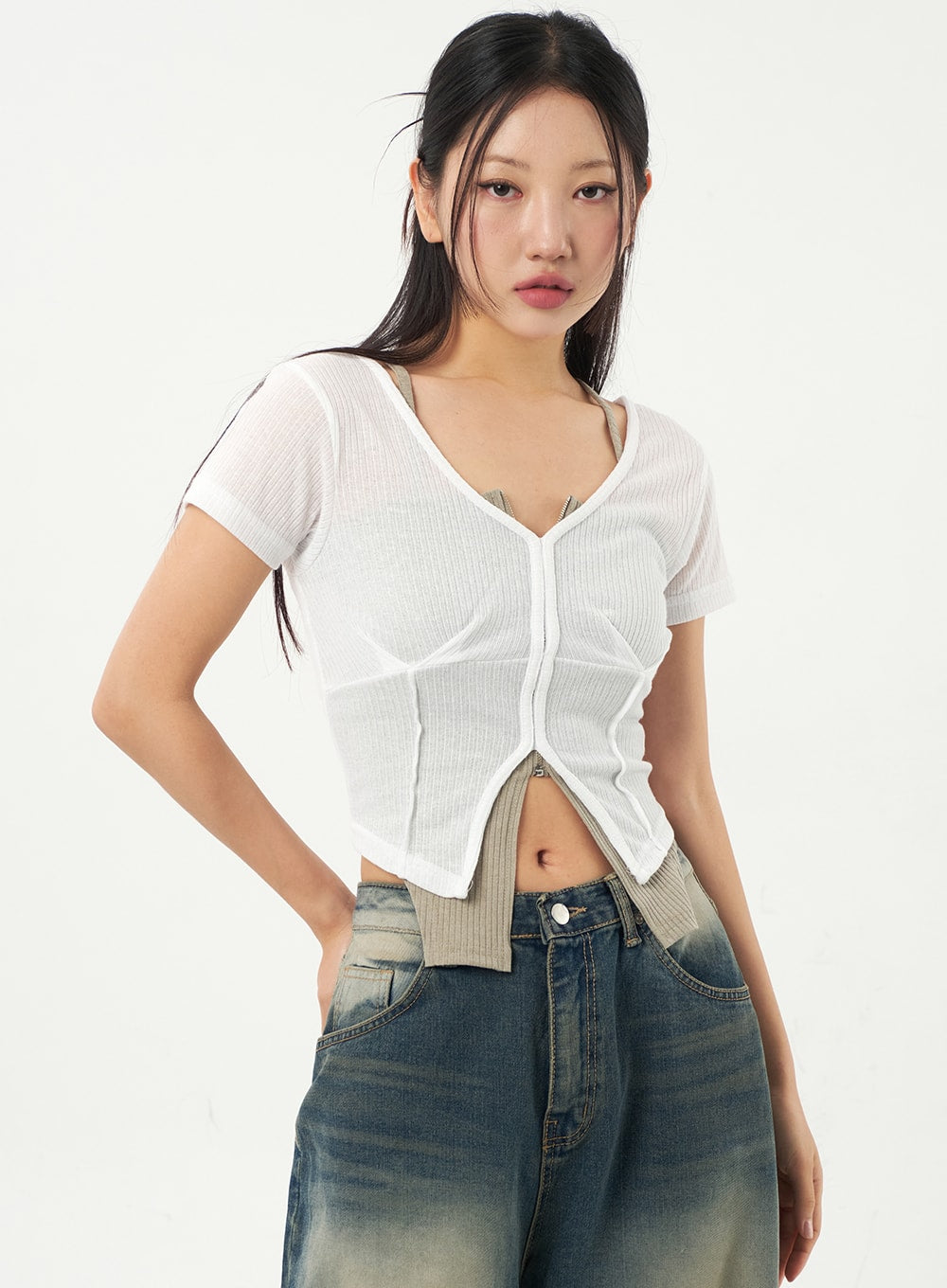 Mid-Rise Baggy Jeans CA325 in vintage blue denim, upper-body and waistband close-up on model, mid-rise fit with visible front pocket seams and faded wash, layered under white sheer crop top.
