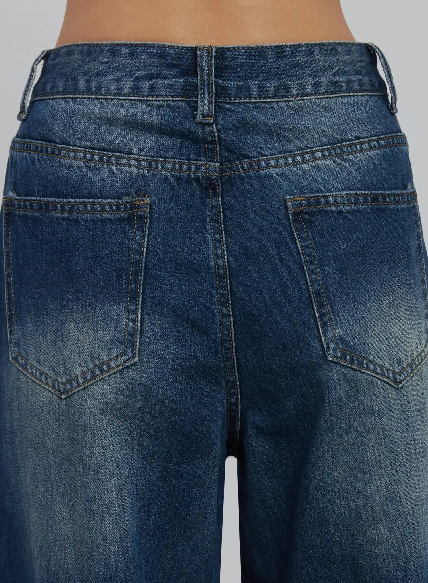 Alaina Wide Leg Jeans IJ508 in dark blue, macro close-up of back pockets and waistband, contrast golden topstitching, washed denim texture with fading detail.