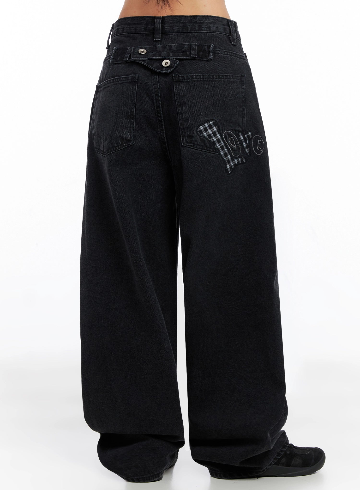 Sunwoo Embroidered Wide Leg Jeans IG528 in black, back three-quarter waist-to-hem shot, featuring gingham plaid heart patch with 'love' embroidery across both back pockets, double-snap waistband detail.
