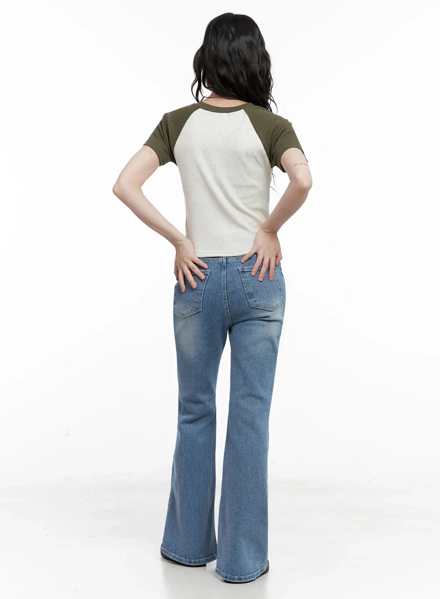 Hikaru High-Waist Flare Jeans IL531 in blue, full back view on model, large back patch pockets visible, washed flare denim, paired with olive and cream raglan tee.