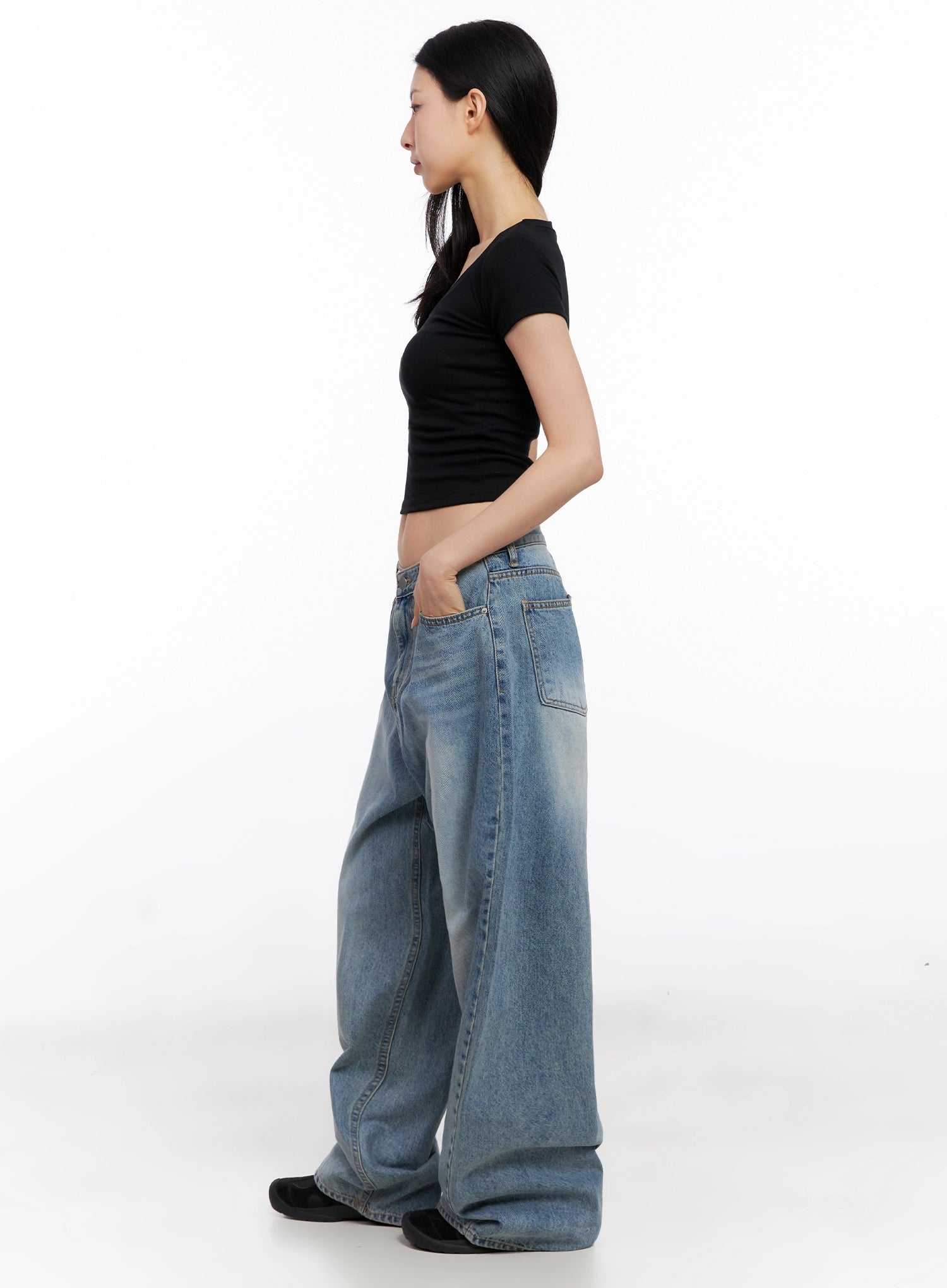Seojin Washed Wide-Leg Jeans IG508 in blue, side profile full-length on model in black crop tee, hand in front pocket, showing sweeping wide-leg silhouette and hem stack.