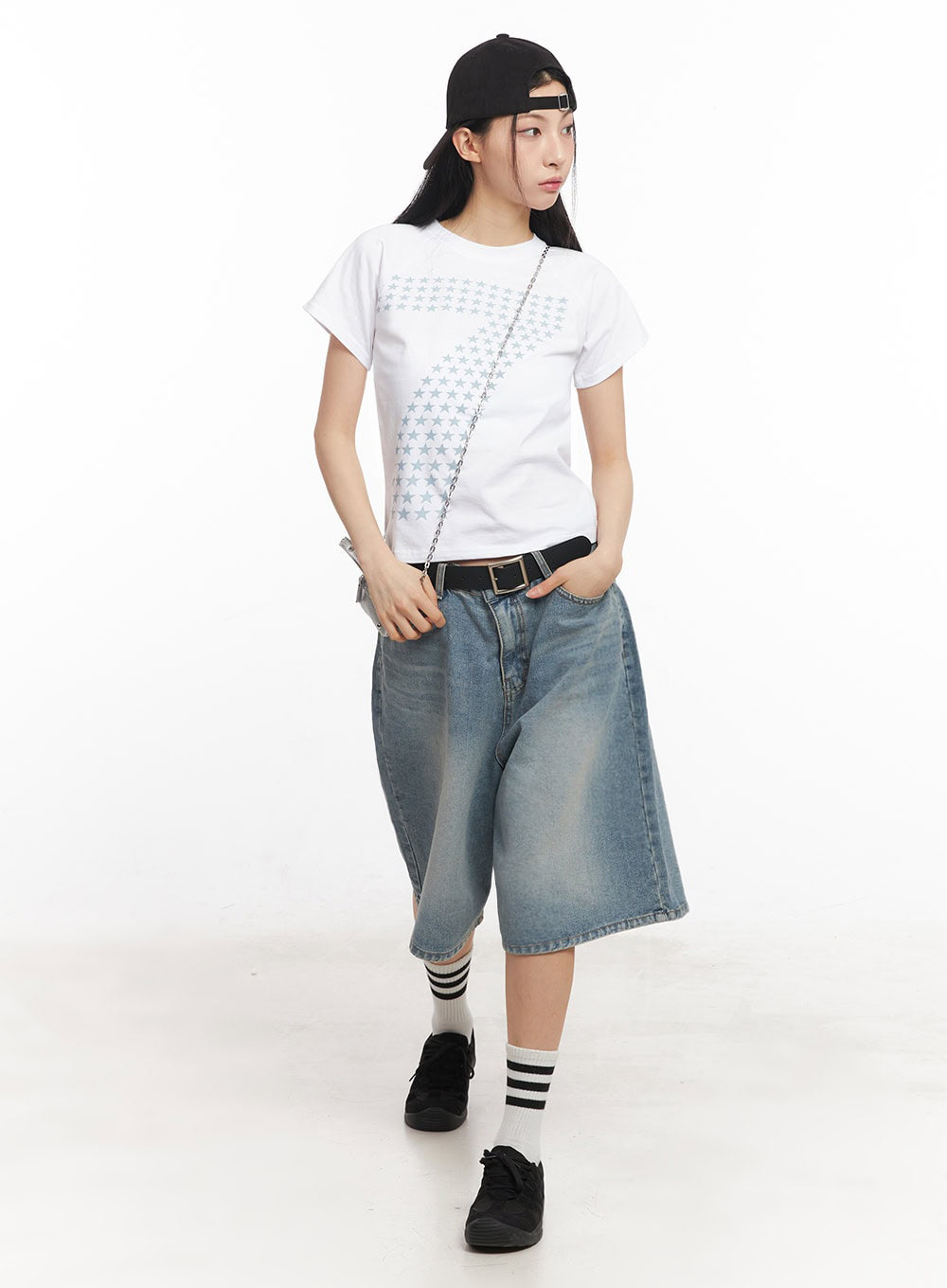 Washed Baggy Jorts IY529 in light blue, full-body front shot on model, wide baggy midi washed denim, walking pose, styled with white star-print tee, black cap, chain bag, and black sneakers.