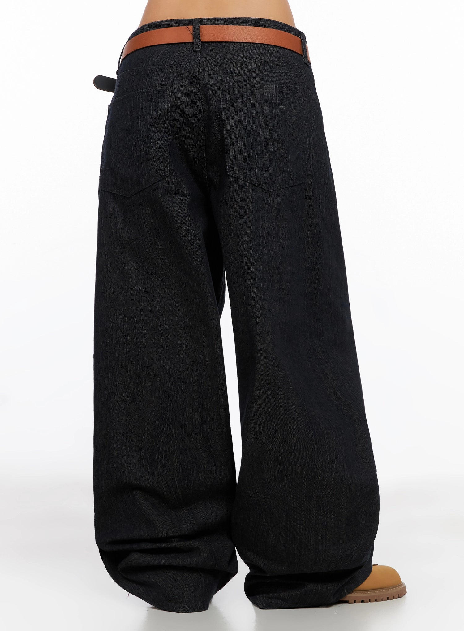 Heidi Wide-Leg Jeans IG527 in dark blue, back 3/4 lower-body view on model, showcasing wide-leg volume, back pocket placement, and floor-length hem pooling at tan boots.