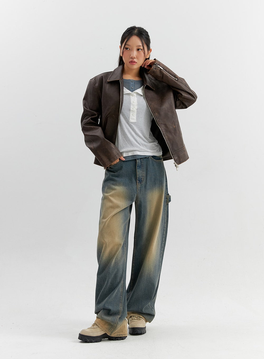 Vintage Wash Wide Leg Jeans CO306 in blue, full-body side view on model, wide-leg vintage-wash denim with bold yellow fade, one hand in pocket, styled with brown leather jacket.