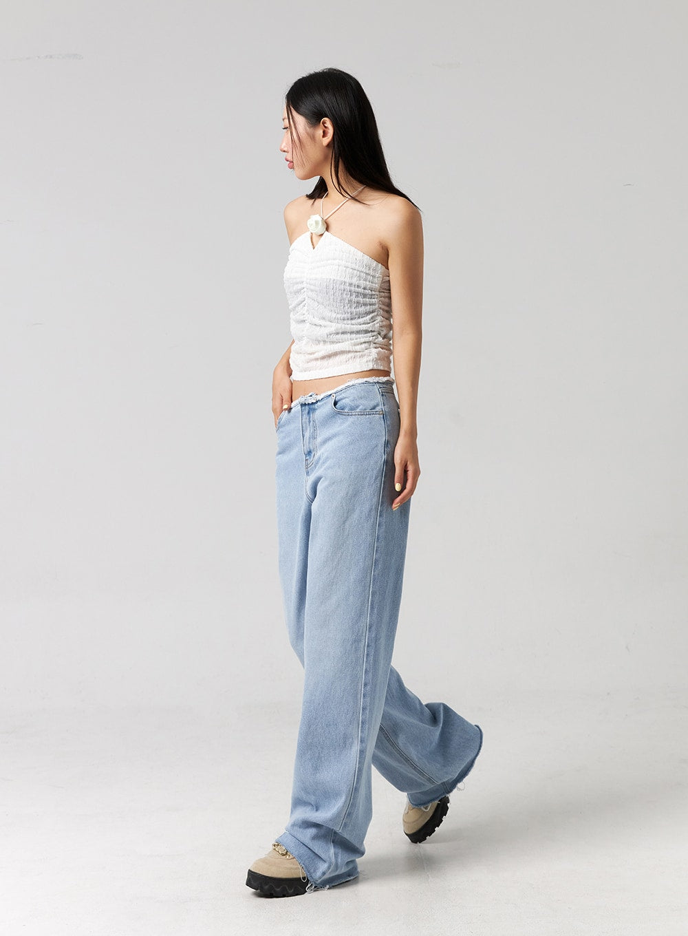 Cut Waist Wide Leg Jeans CG323 in light blue, side full-length shot on model mid-stride, wide-leg cotton denim showing volume and length, frayed cut waist and raw hem at floor.