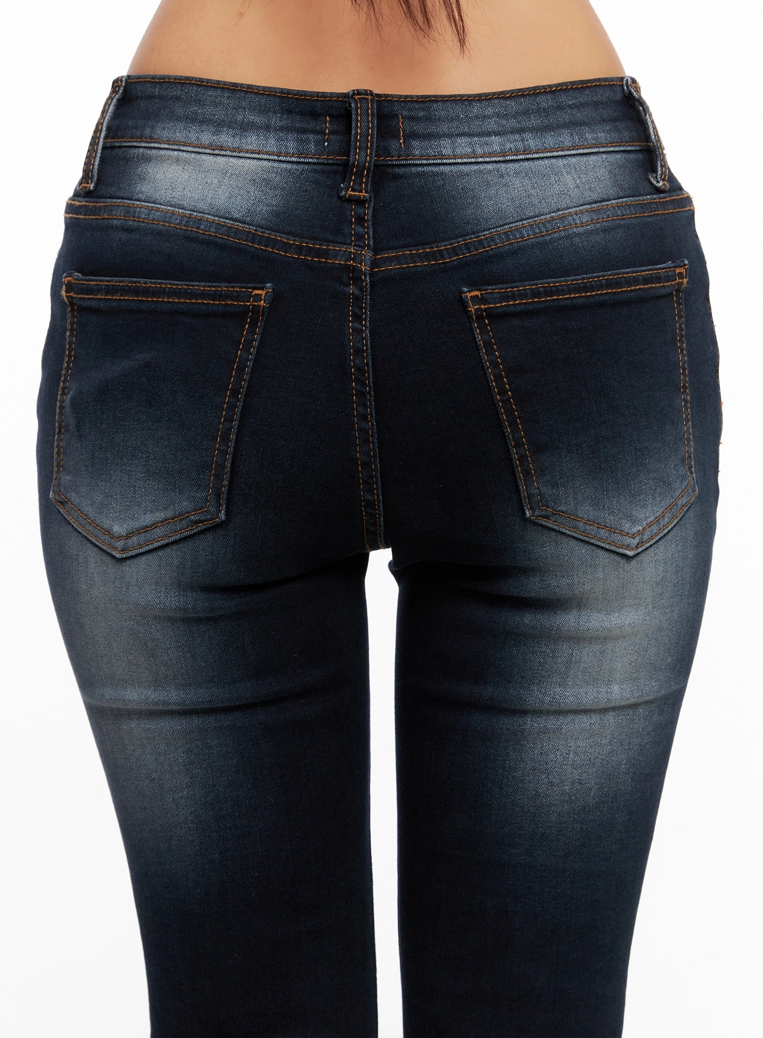 Aliyah Mid-Rise Hip Pad Flared Jeans IG528 in dark blue, back waist close-up detail on model, hip pad shaping, dual back pockets with contrast topstitching, and washed denim texture visible.