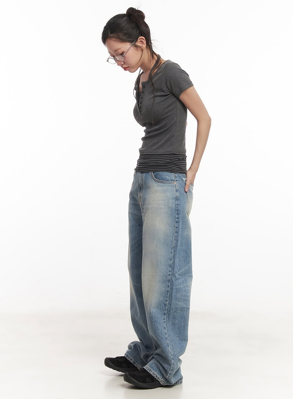 Lumira Back-Detail Washed Wide Leg Jeans CA530 in blue, side view on model looking down, washed wide-leg denim showing voluminous silhouette and fade gradient, paired with grey top.