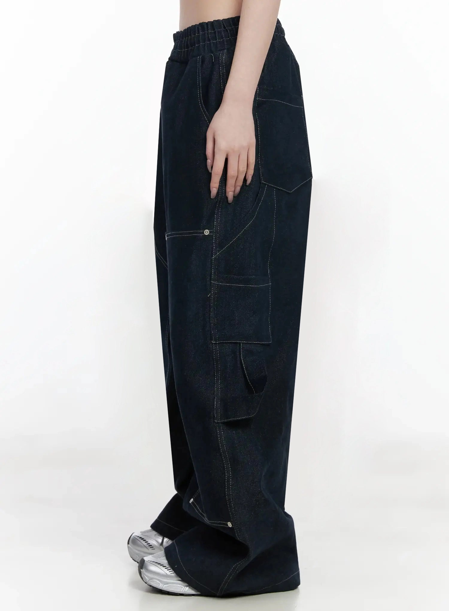 Ashlyn Carpenter Wide-Leg Jeans IJ528 in dark blue, side product shot on model, full-length profile showing layered cargo pocket and contrast stitching seams, wide-leg hem pooling at floor.