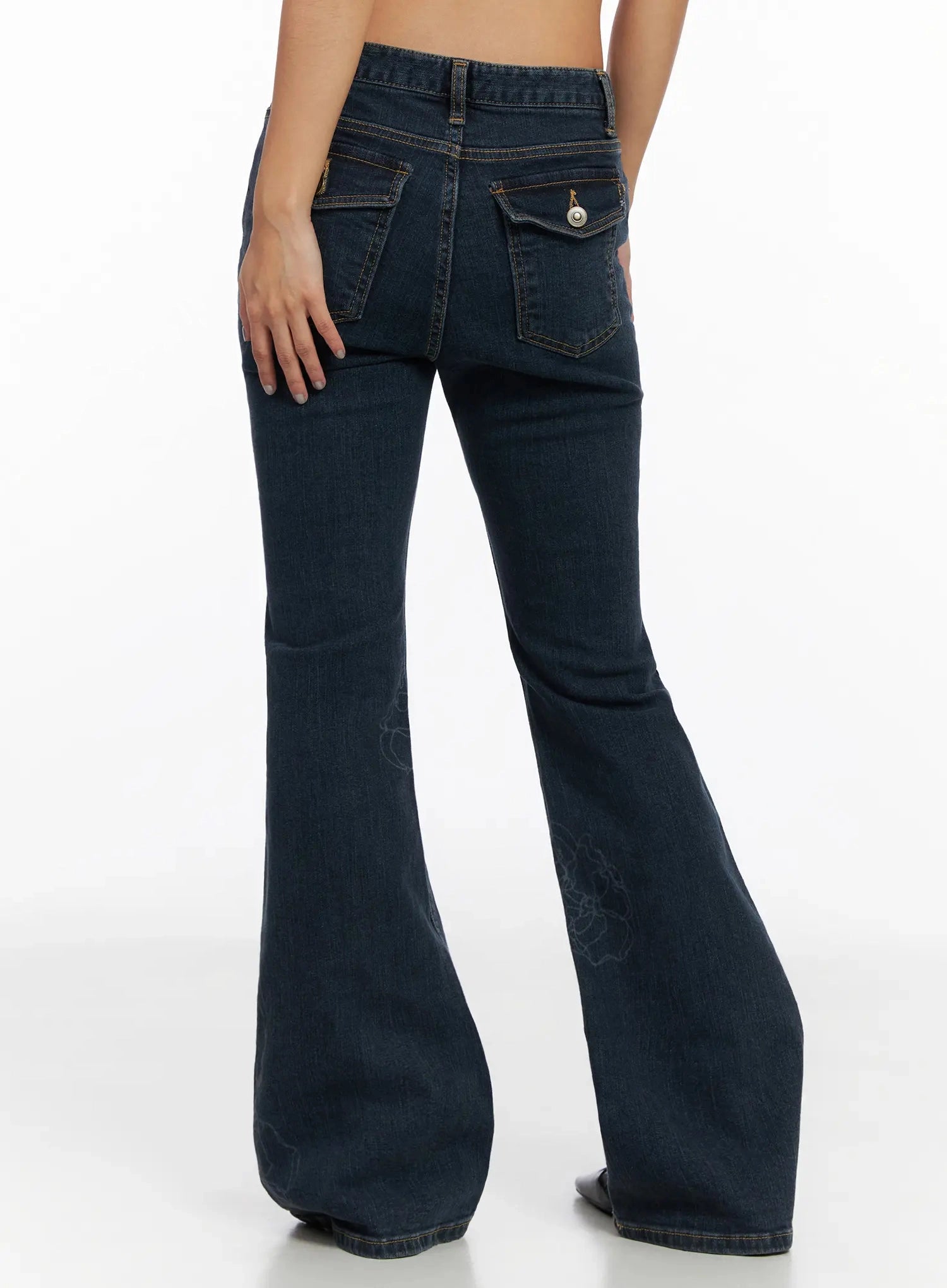 Amari Floral Embriodered Bootcut Jeans IN528 in dark blue, back three-quarter shot waist to hem on model, dual flap back pockets with gold snap and zipper hardware, bootcut flare with subtle floral stitch.