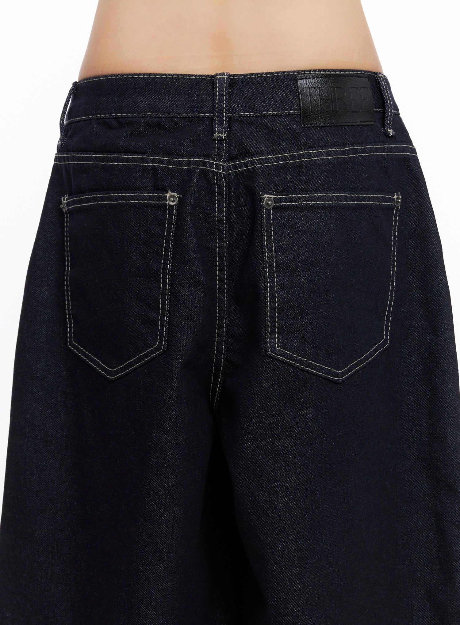 Jazlyn Non-Fade Button Wide Leg Jeans IN503 in dark blue, close-up back detail of rear pockets, contrast white topstitching, leather label tab, and denim texture on model.